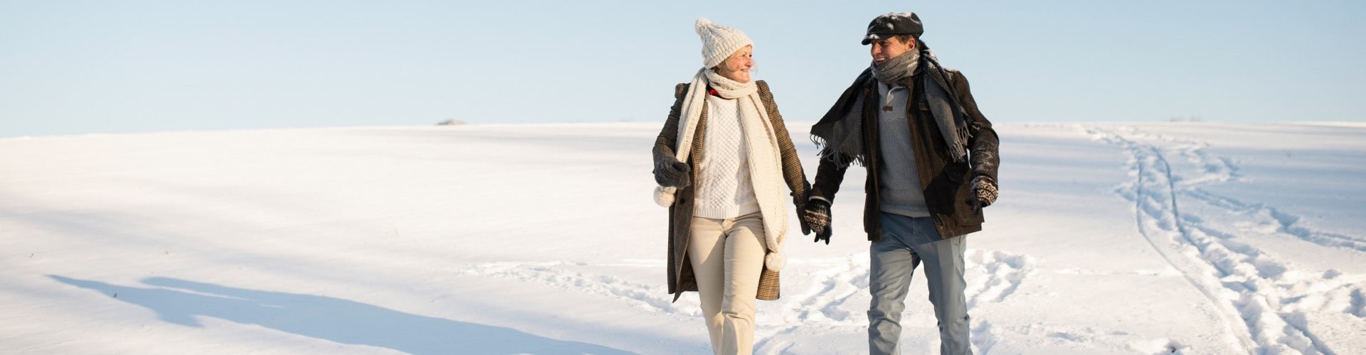 senior couple hiking through the snow